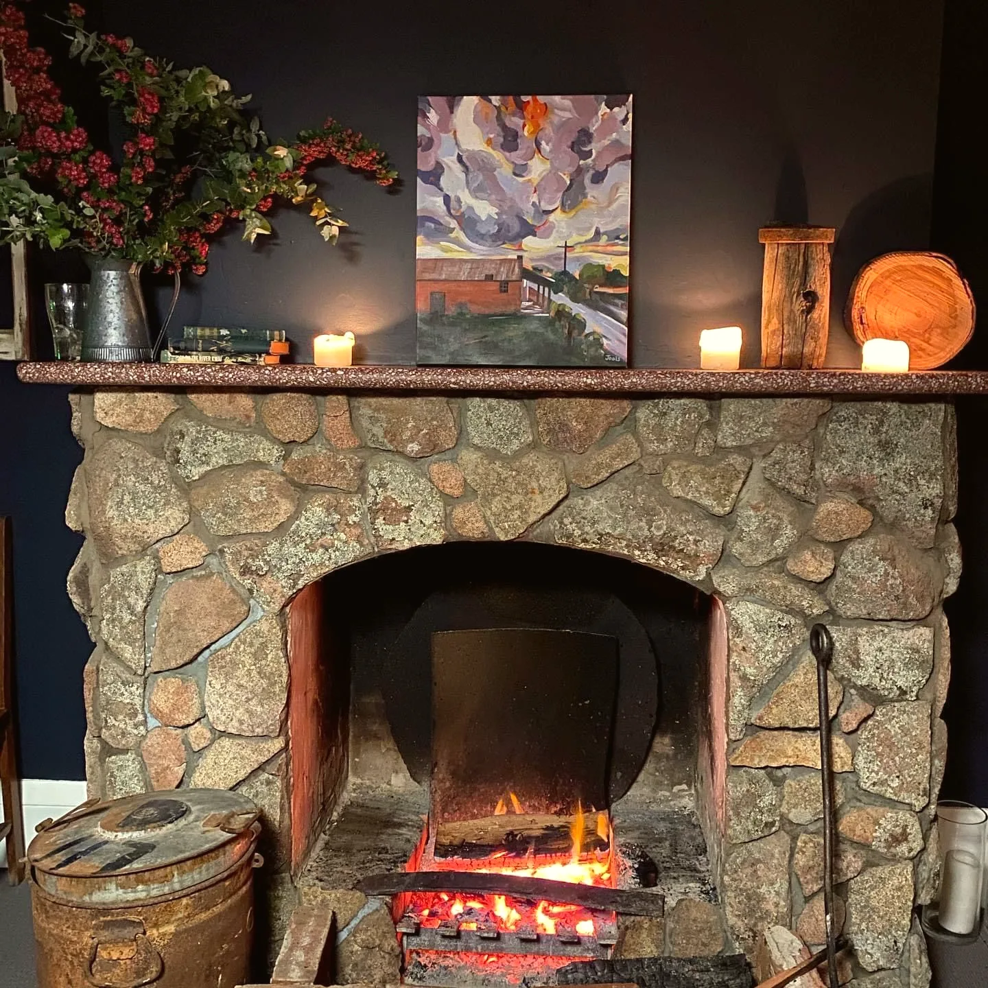 The stone fireplace in the front bar with the fire lit.